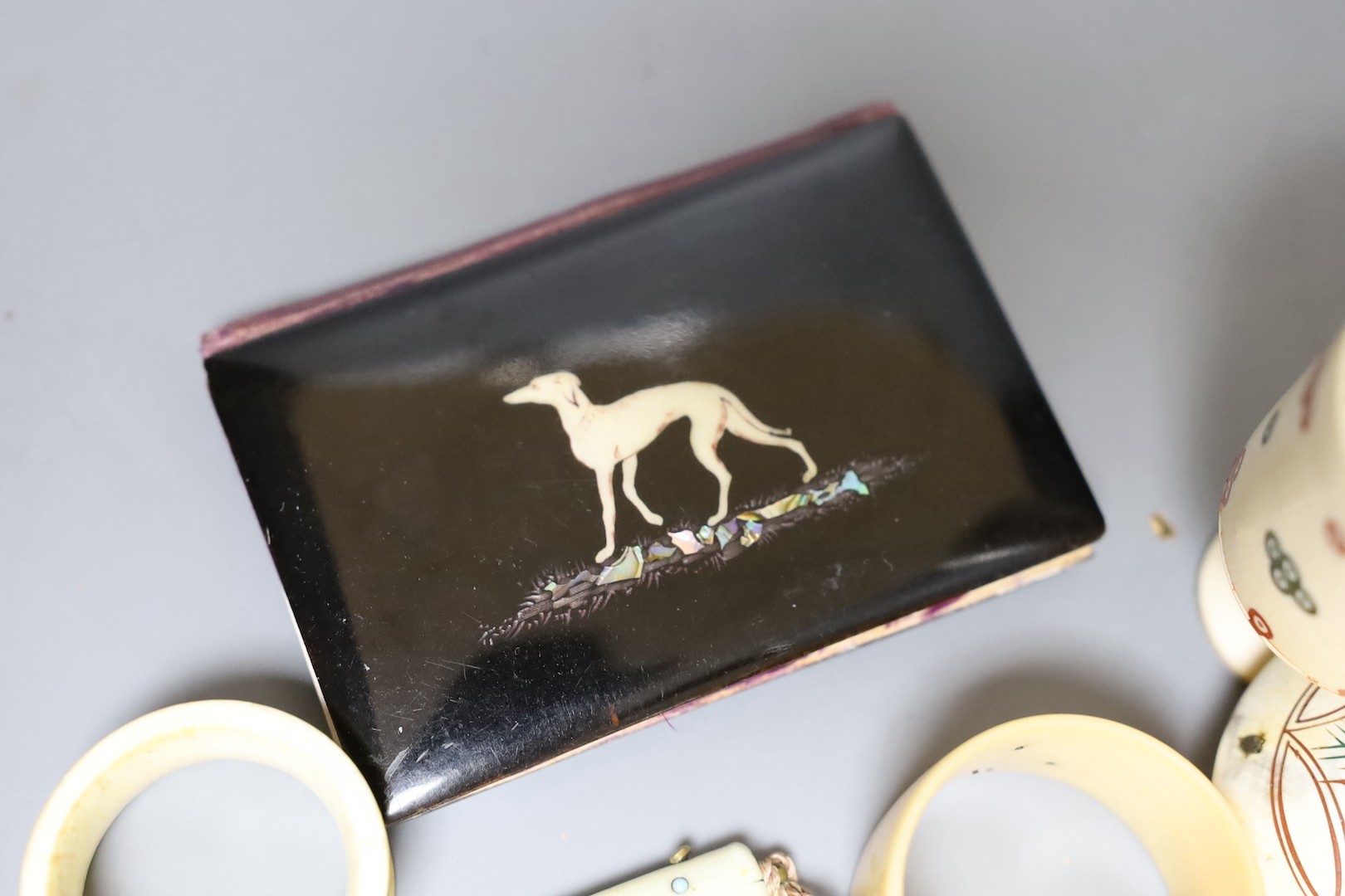 A George III ivory needle case, 6cm. a Victorian card purse inlaid with a whippet, 9.5cm, a horn snuff box and four other items.